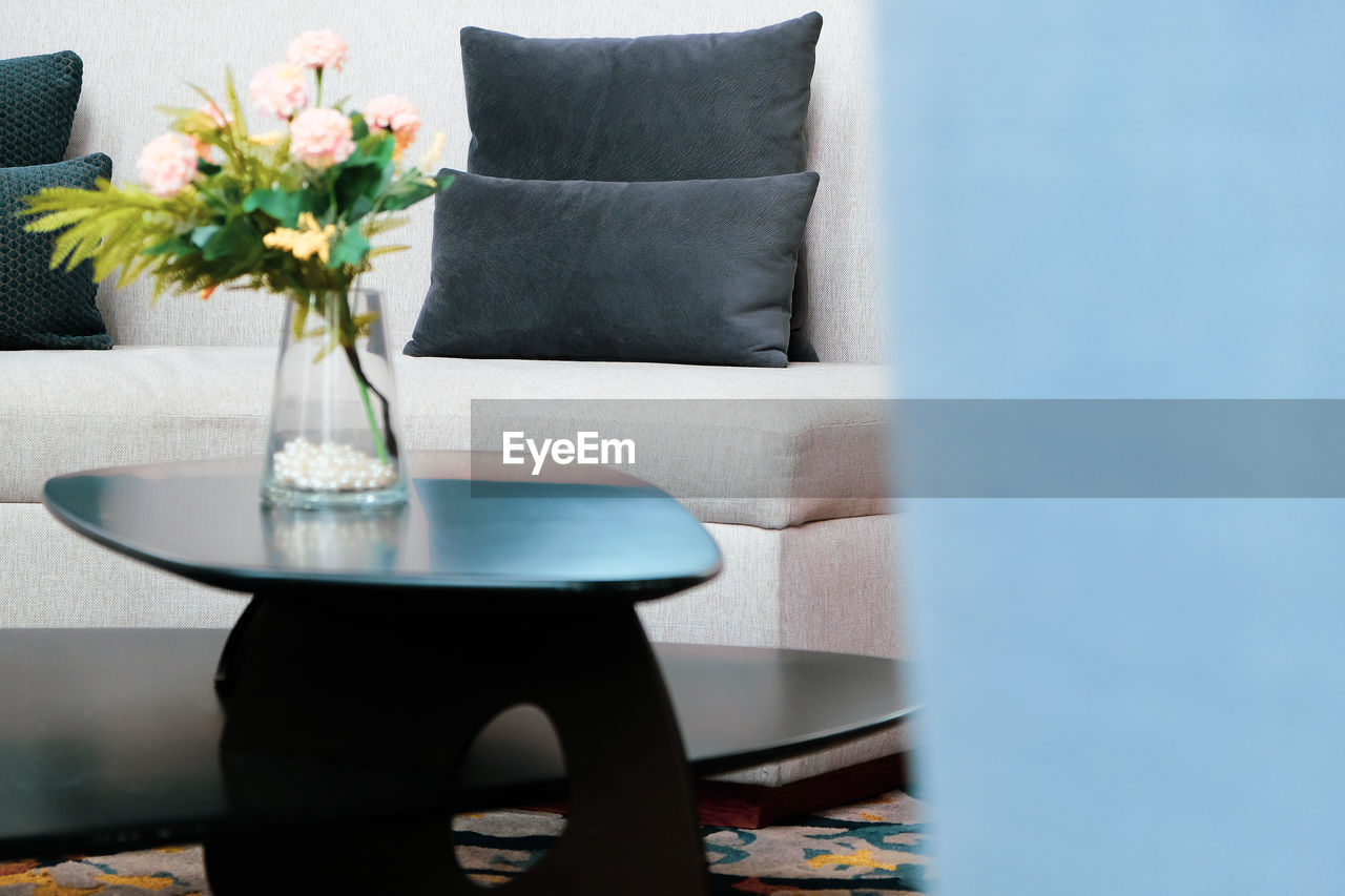 FLOWER VASE ON TABLE AGAINST WALL AT HOME