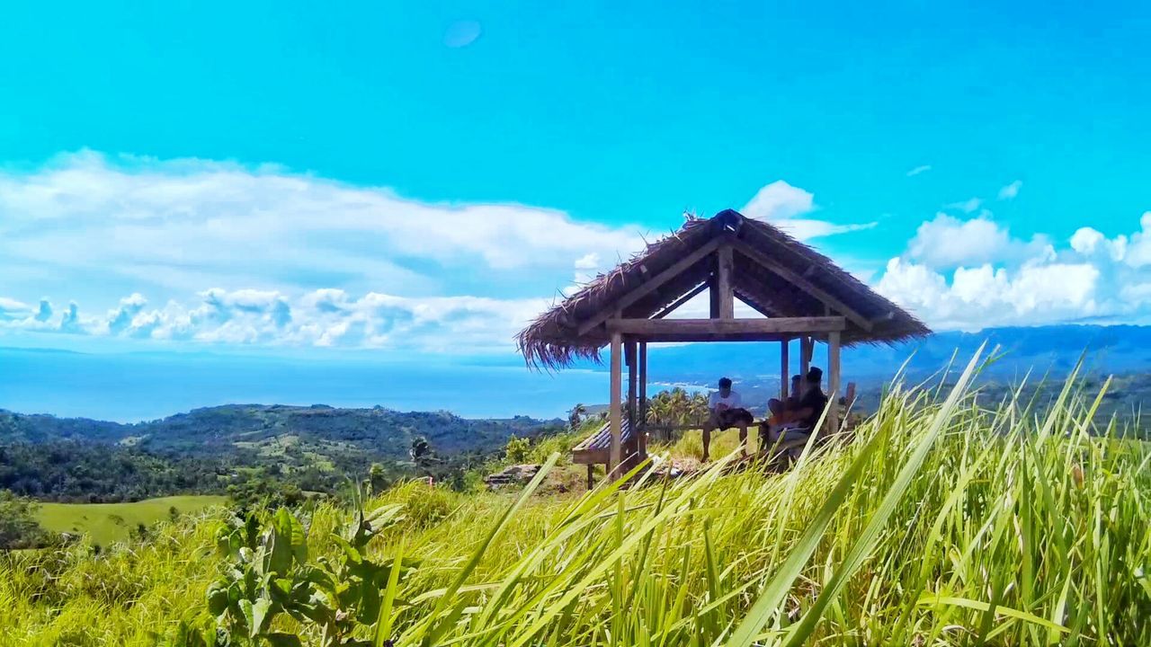 LIFEGUARD HUT ON LANDSCAPE AGAINST BLUE SKY