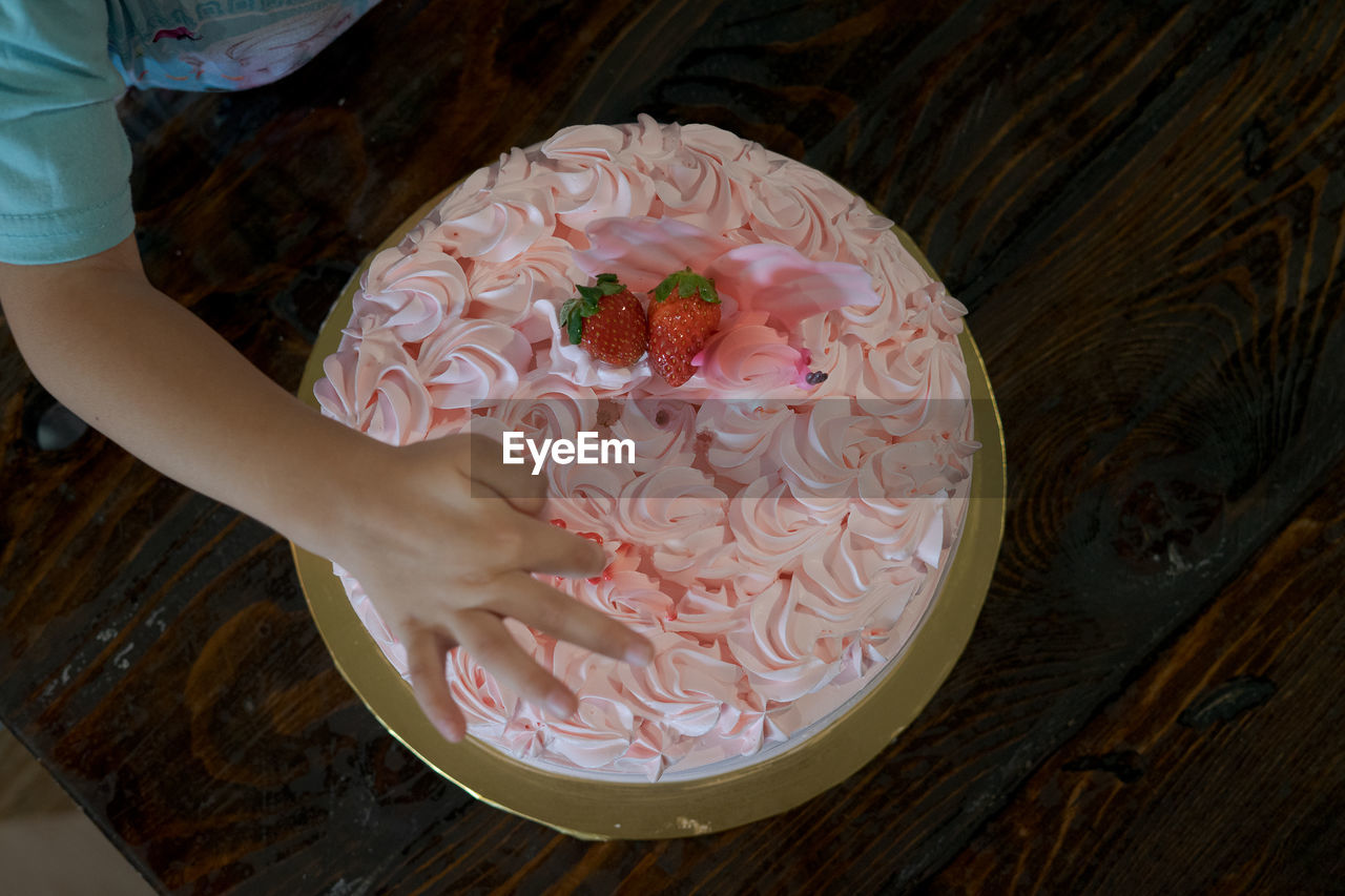 High angle view of hand holding cake