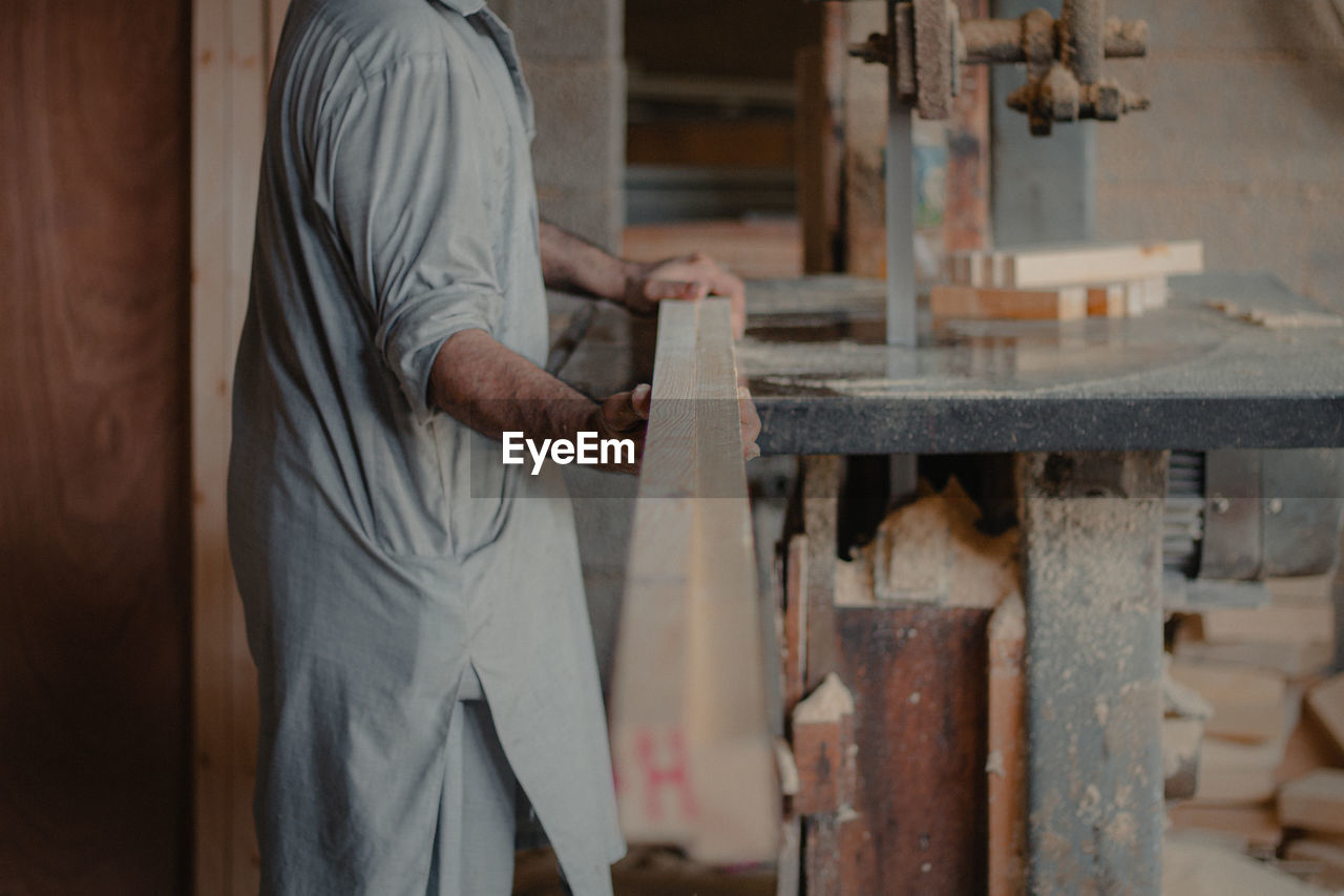Midsection of man working at workshop