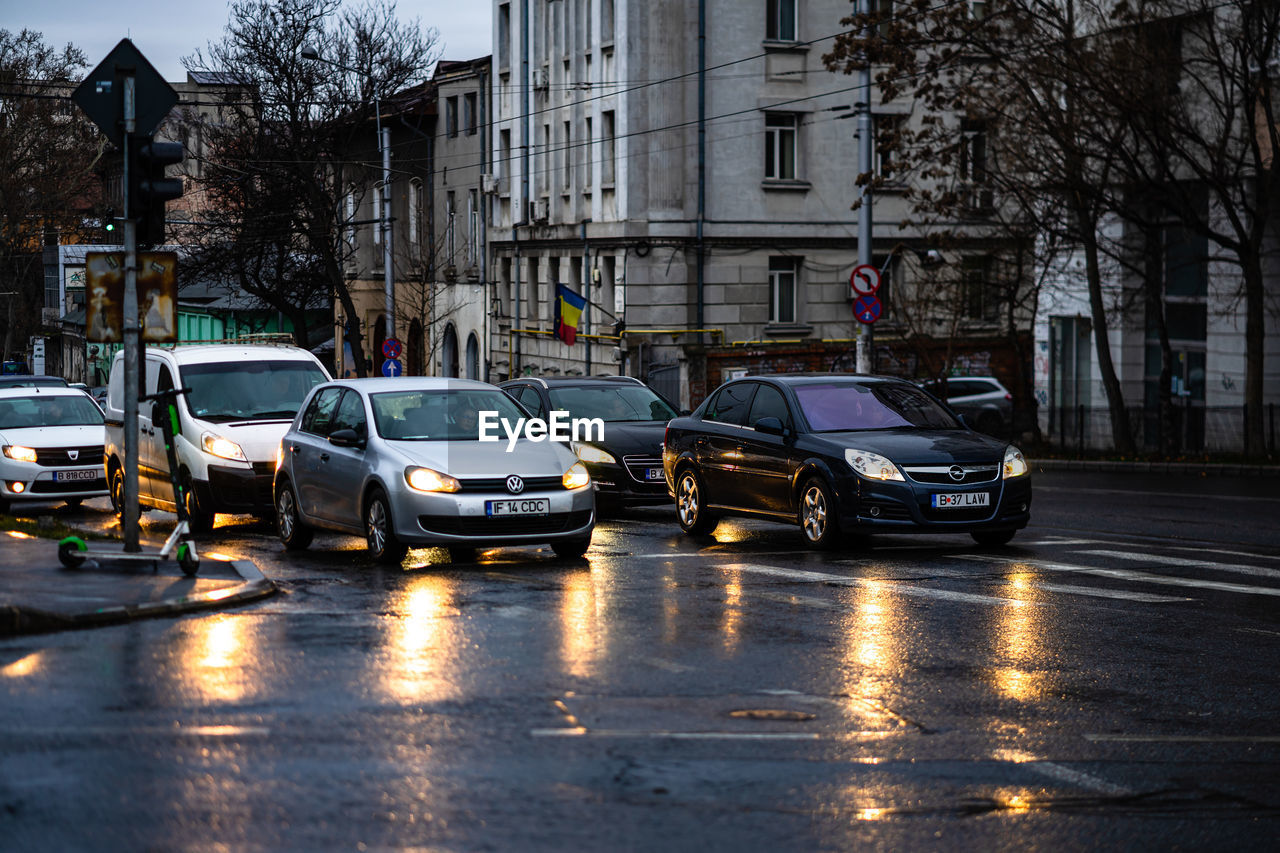 CARS ON STREET AMIDST BUILDINGS IN CITY