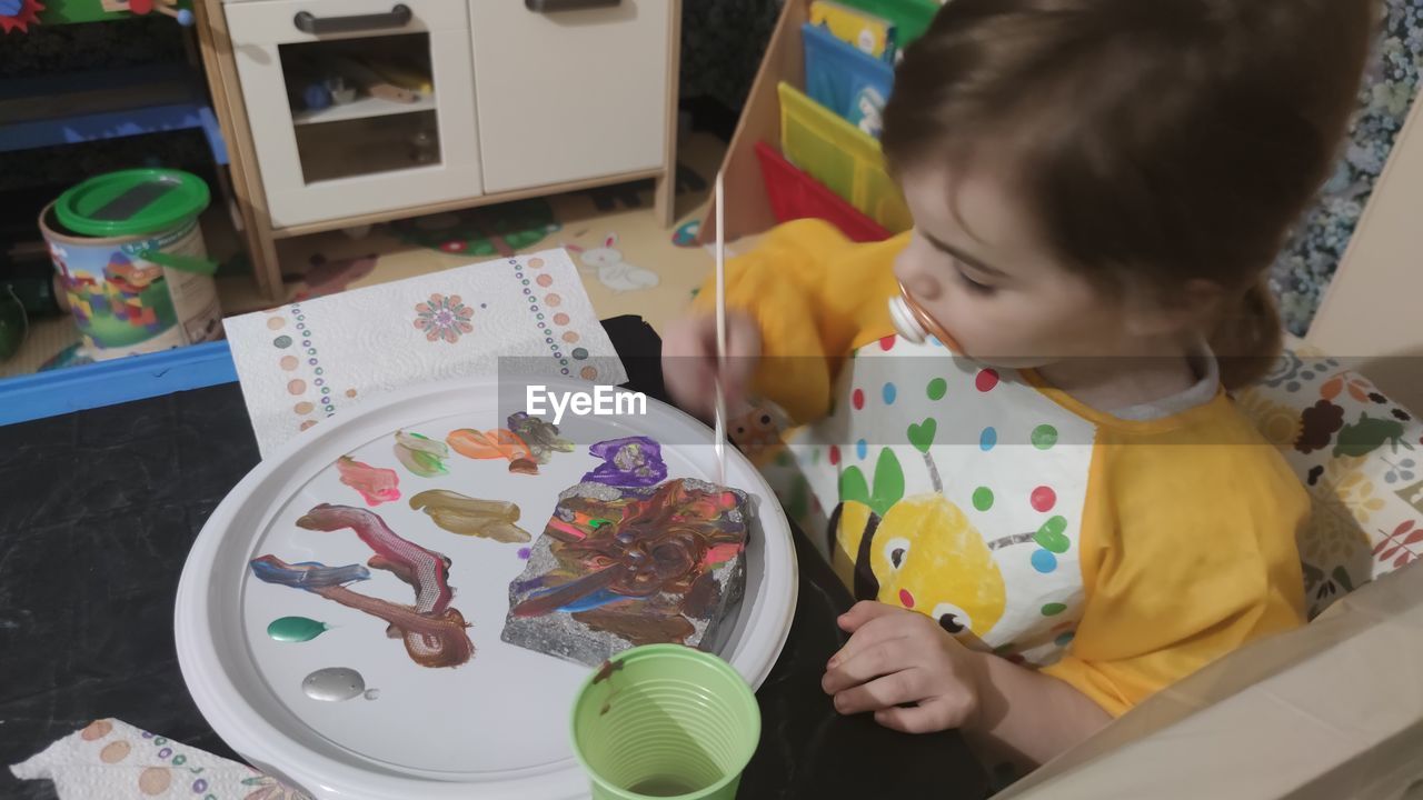 HIGH ANGLE VIEW OF GIRL ON TABLE IN KITCHEN