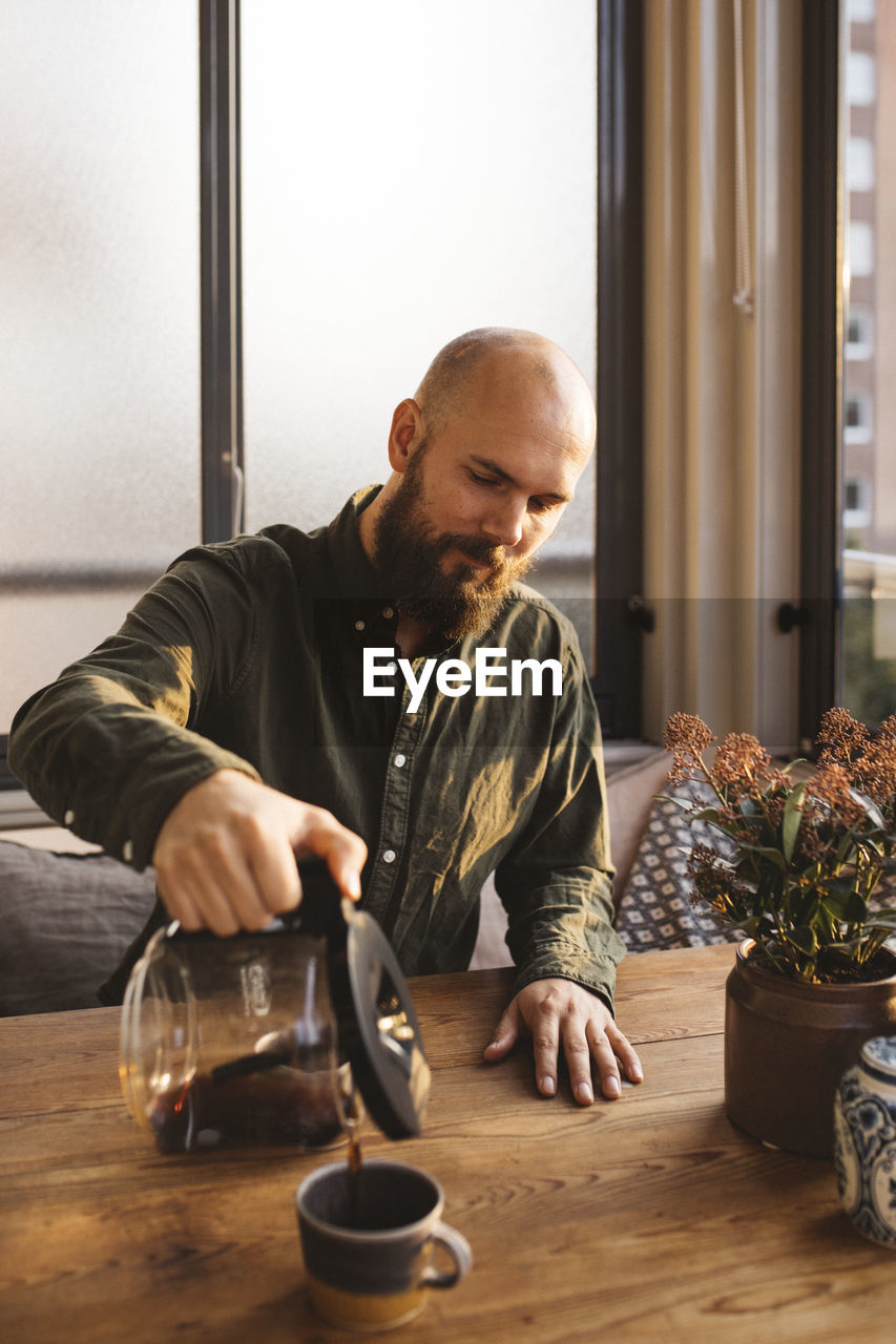 Man pouring coffee into mug