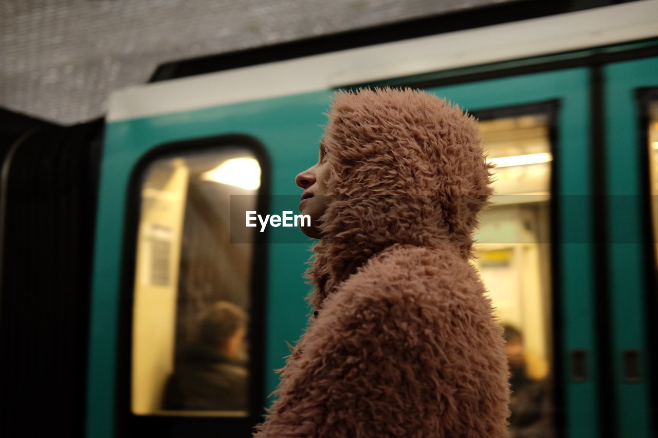 Low angle view of woman in fur coat at railroad station