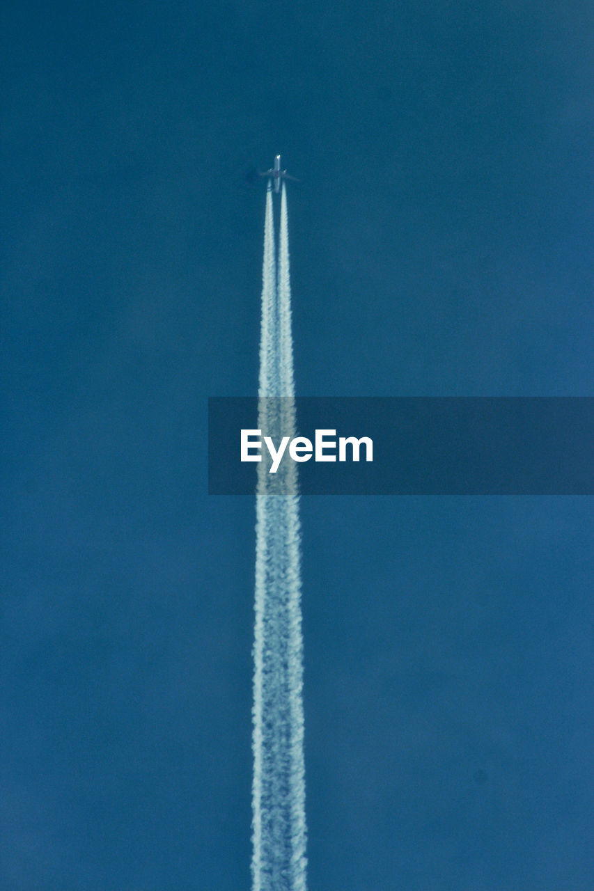 Low angle view of airplane flying against blue sky