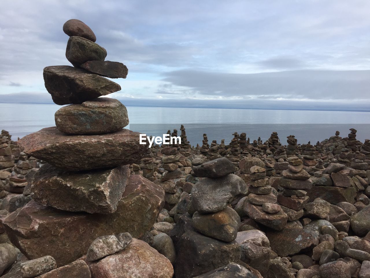 Stack of stones on beach against sky