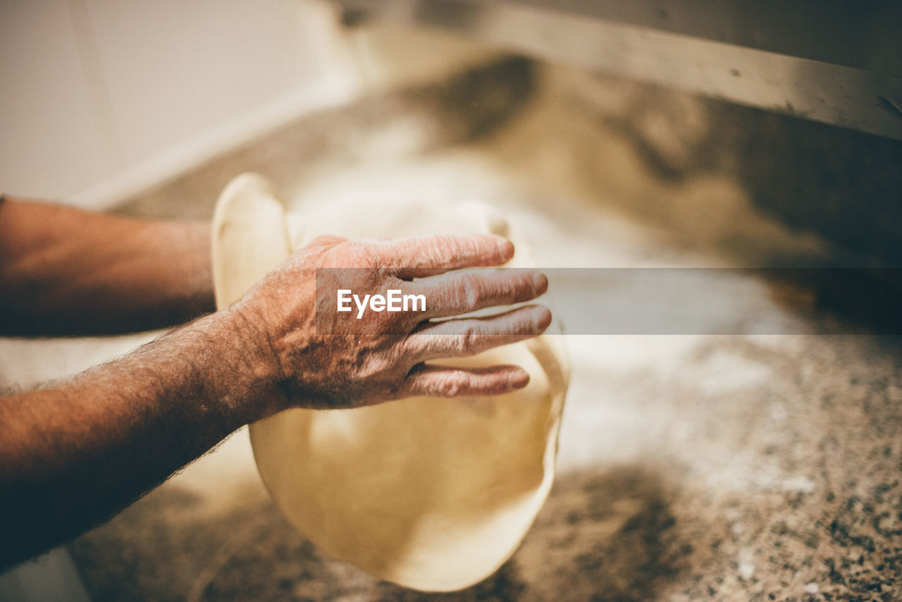 CLOSE-UP OF HAND HOLDING BREAD