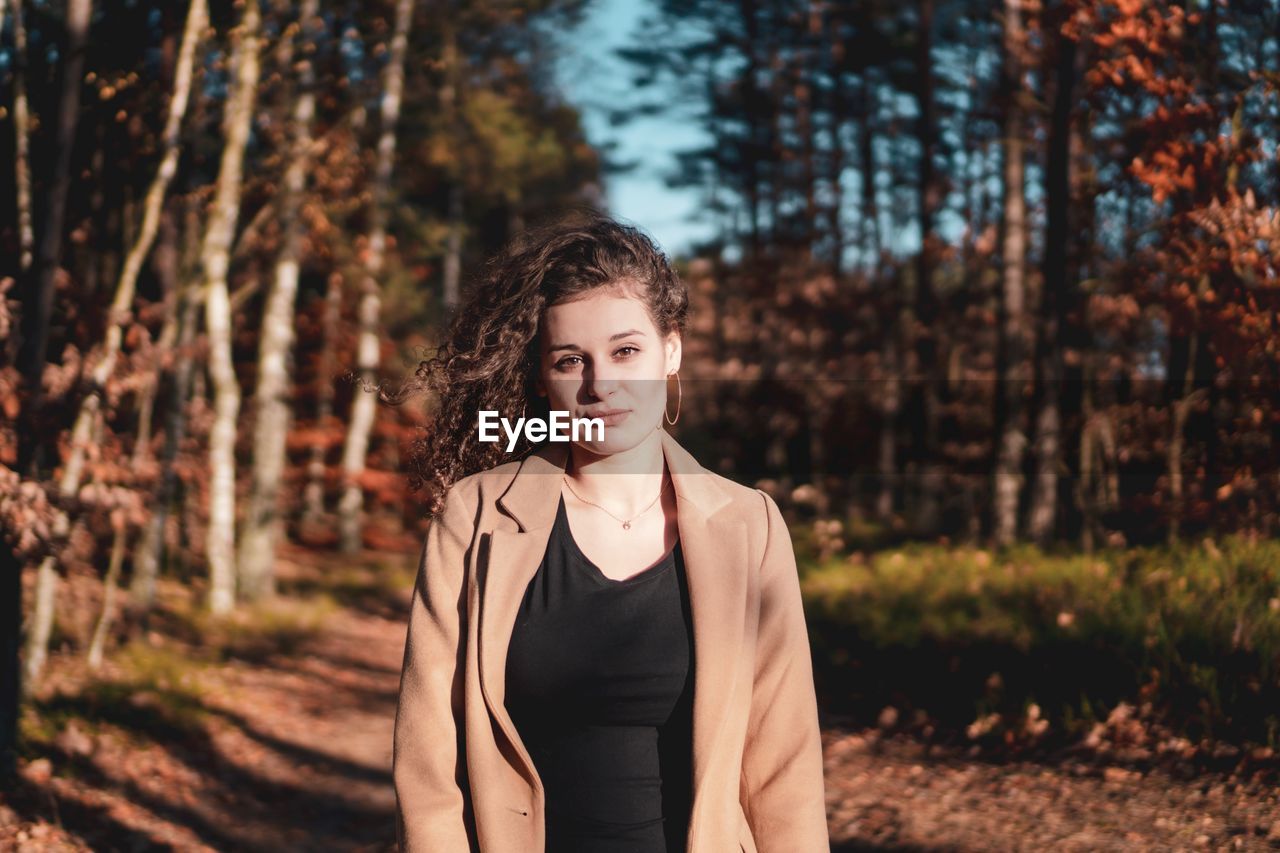 Portrait of young woman standing in forest