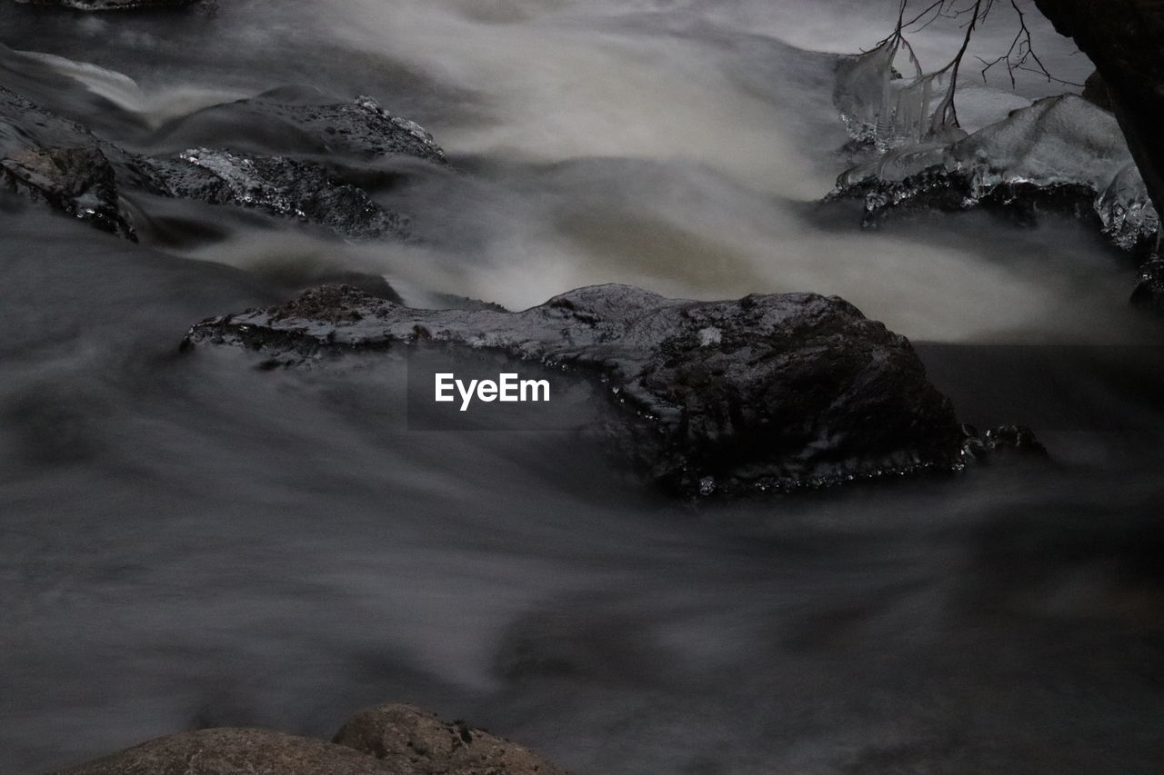 SCENIC VIEW OF WATERFALL AGAINST ROCKS