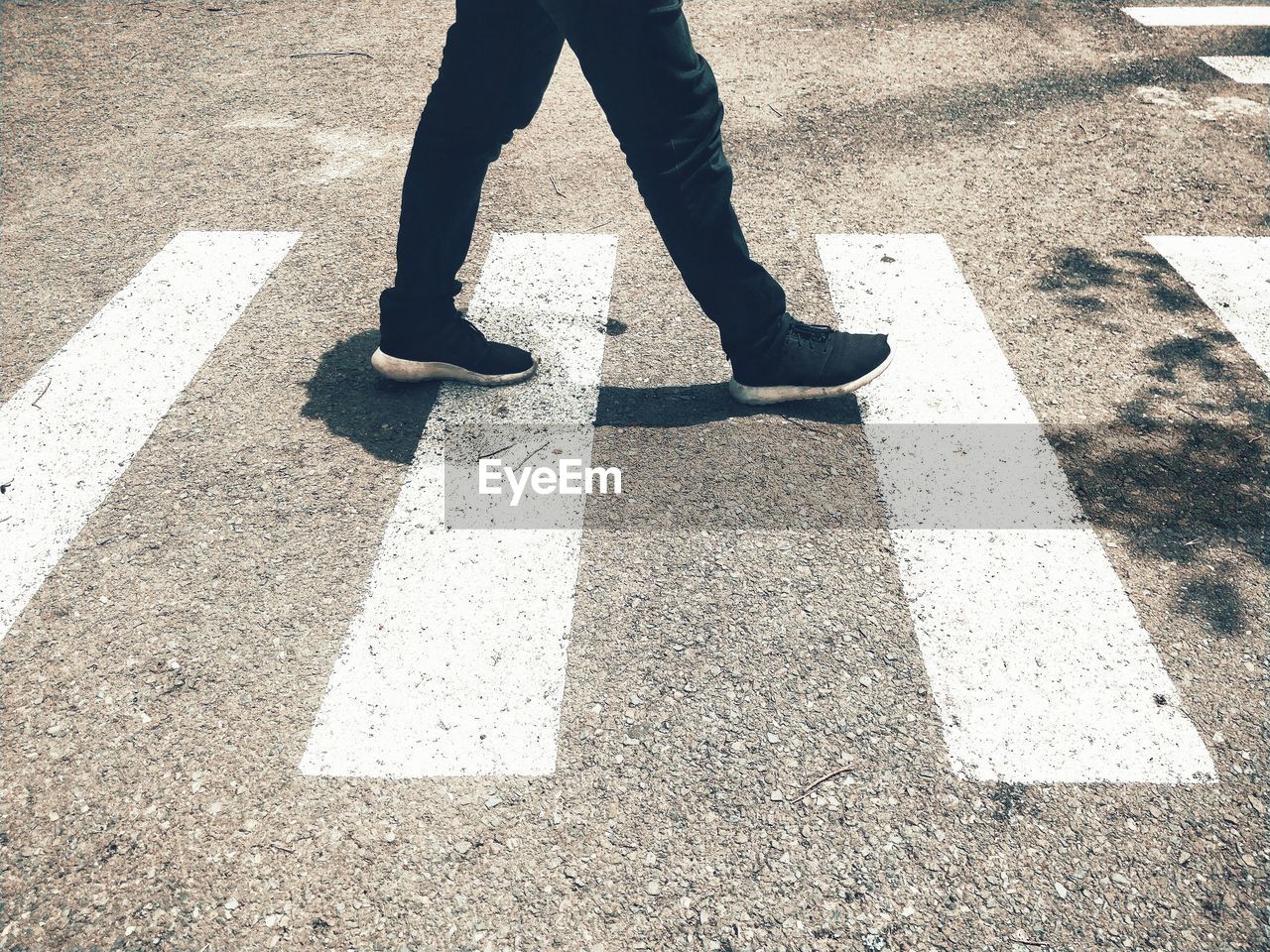 LOW SECTION OF PERSON STANDING BY ROAD