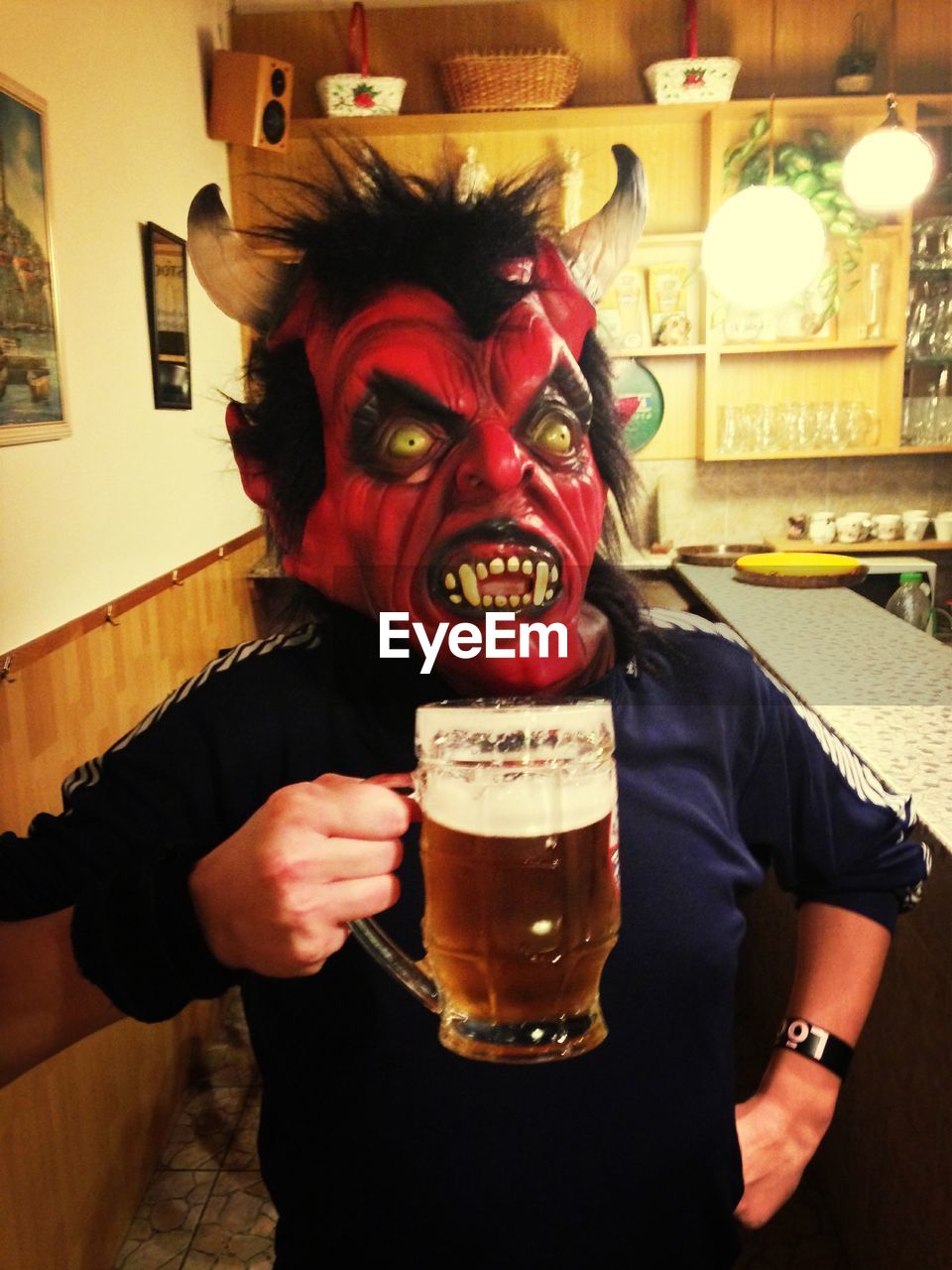 Man in mask holding beer glass