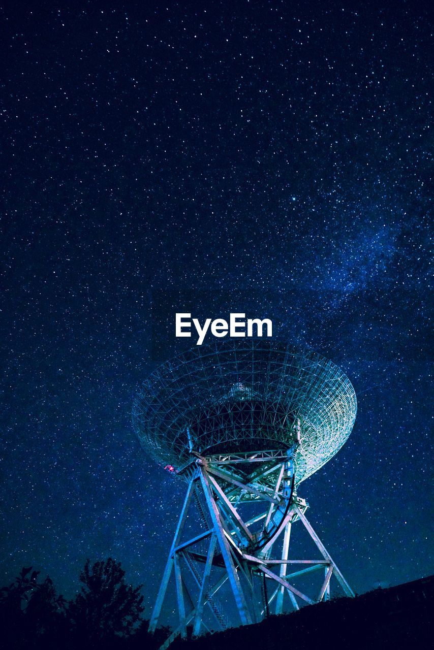 Low angle view of satellite dish against star field
