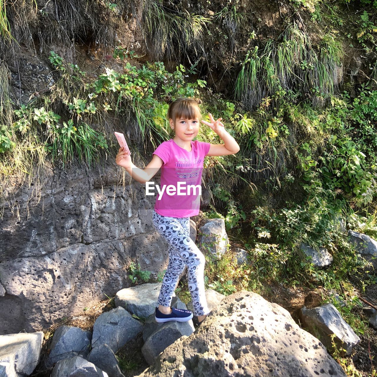 GIRL STANDING ON ROCK