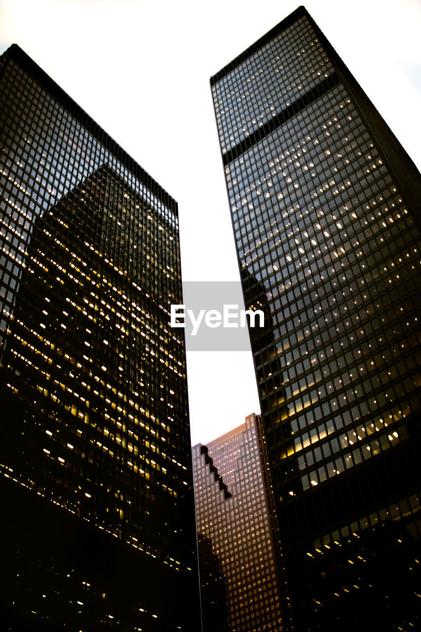 Low angle view of modern buildings against sky in city at dusk