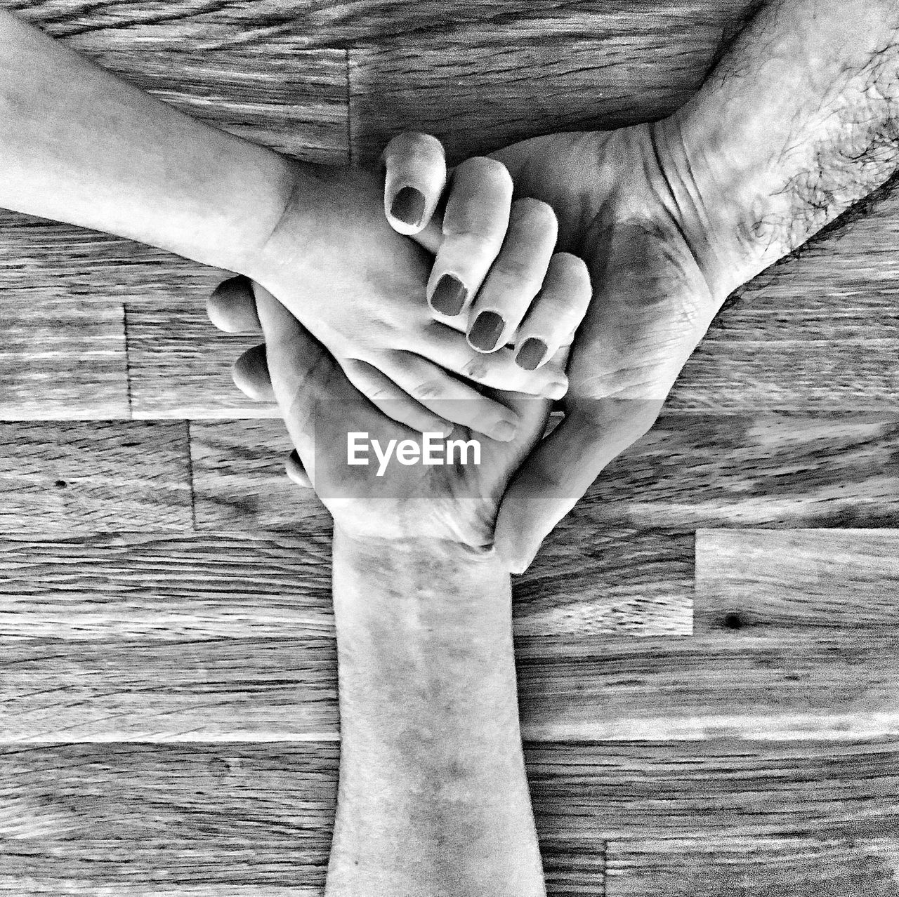 Cropped image of family with holding hands on table