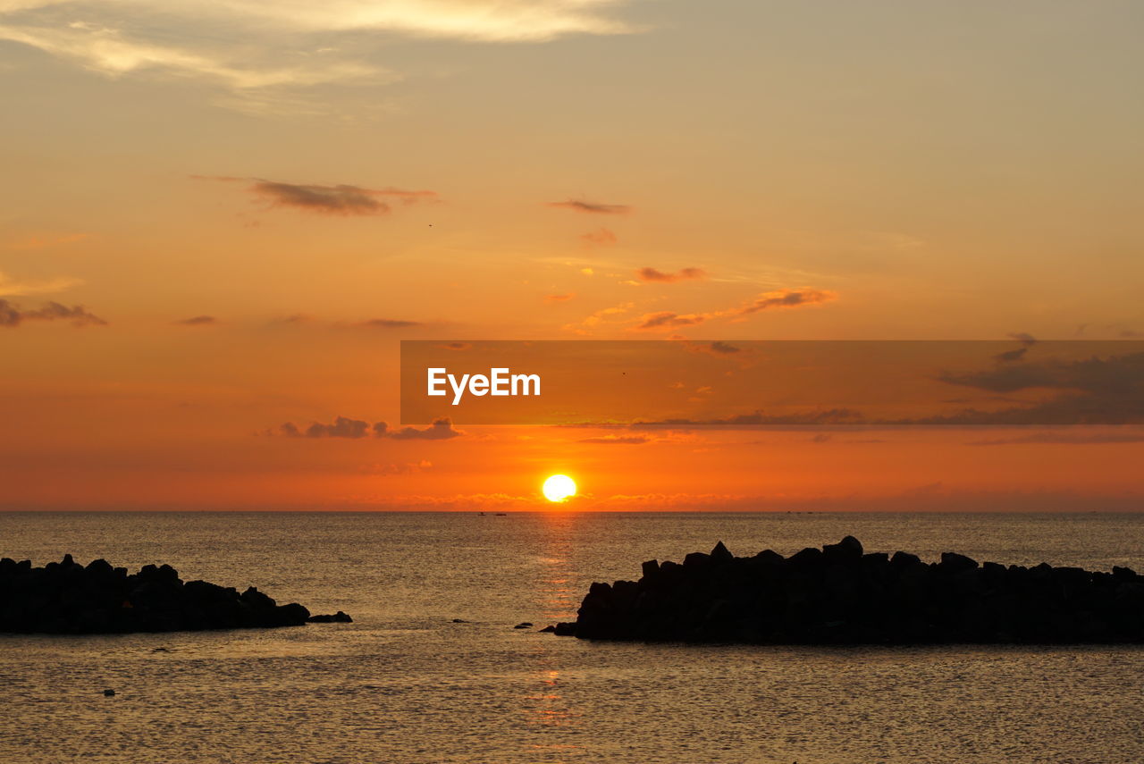 Scenic view of sea against romantic sky at sunset