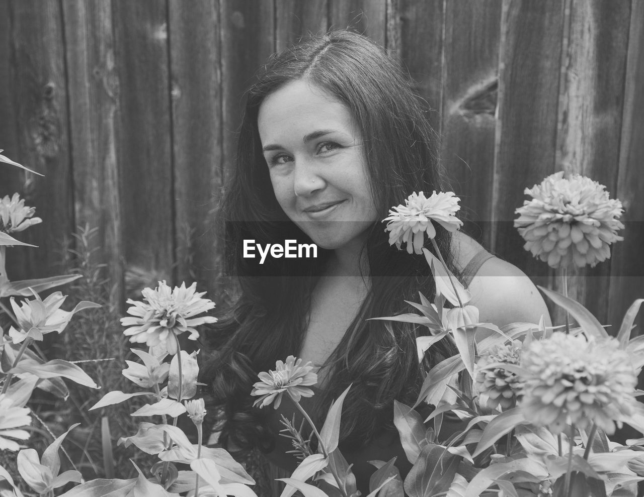 Portrait of smiling woman by flowering plants