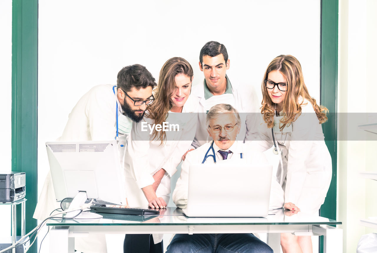 Doctors discussing over computer in hospital