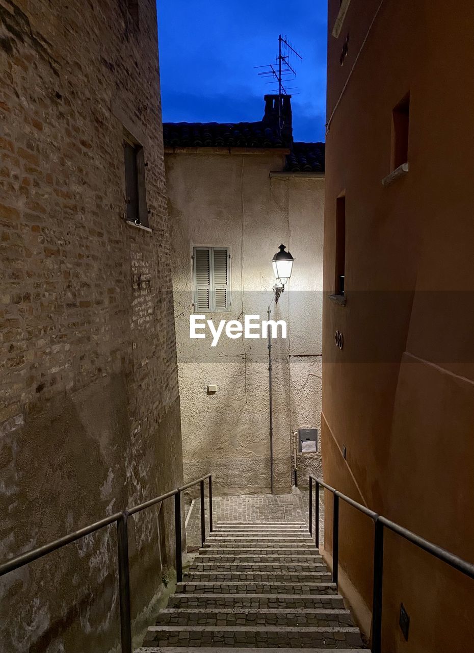 architecture, built structure, building exterior, wall, building, alley, staircase, light, house, sky, no people, lighting equipment, street light, street, city, nature, railing, illuminated, night, wall - building feature, road, steps and staircases, outdoors, the way forward, residential district, narrow, darkness