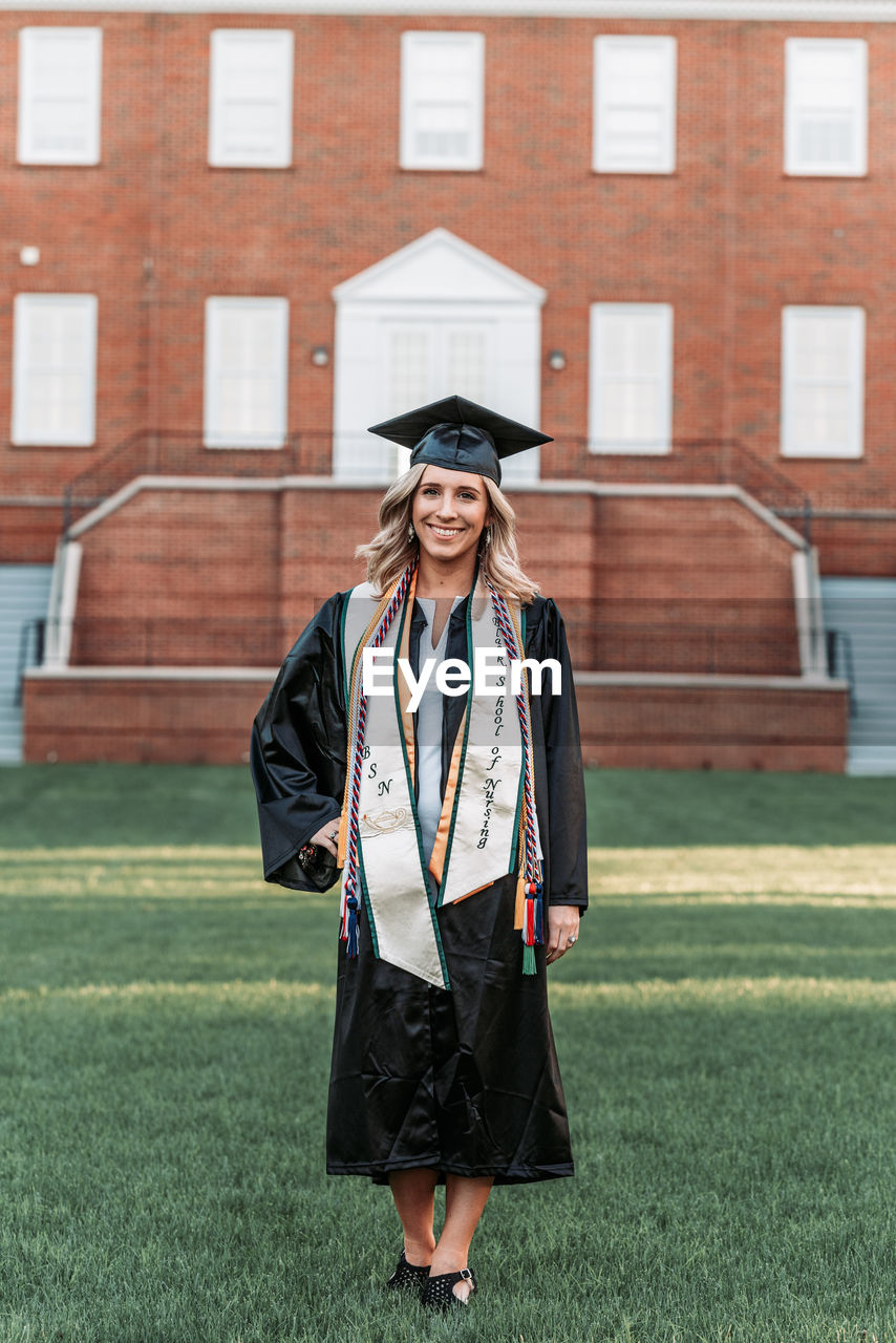 FULL LENGTH OF BEAUTIFUL YOUNG WOMAN STANDING AGAINST WALL