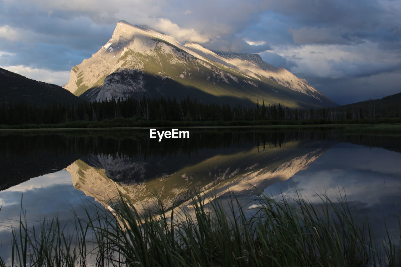 Scenic view of lake by mountain against sky