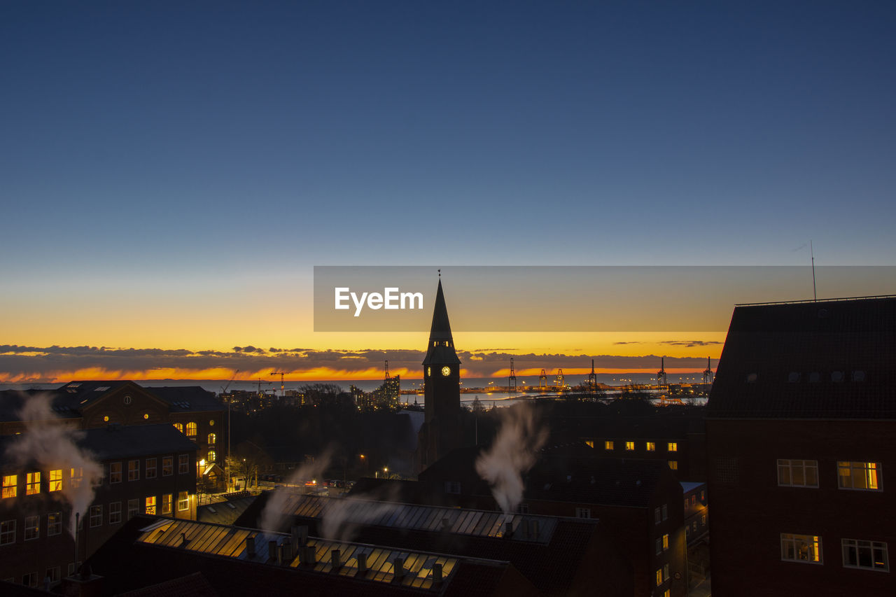 View of illuminated buildings against sky at sunset