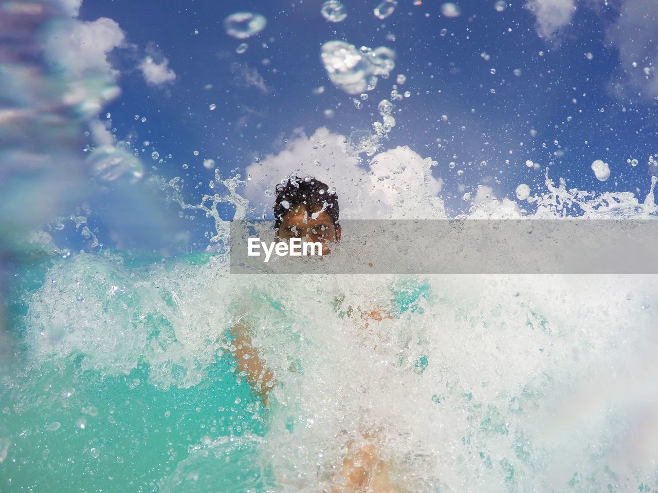 Man splashing water in swimming pool