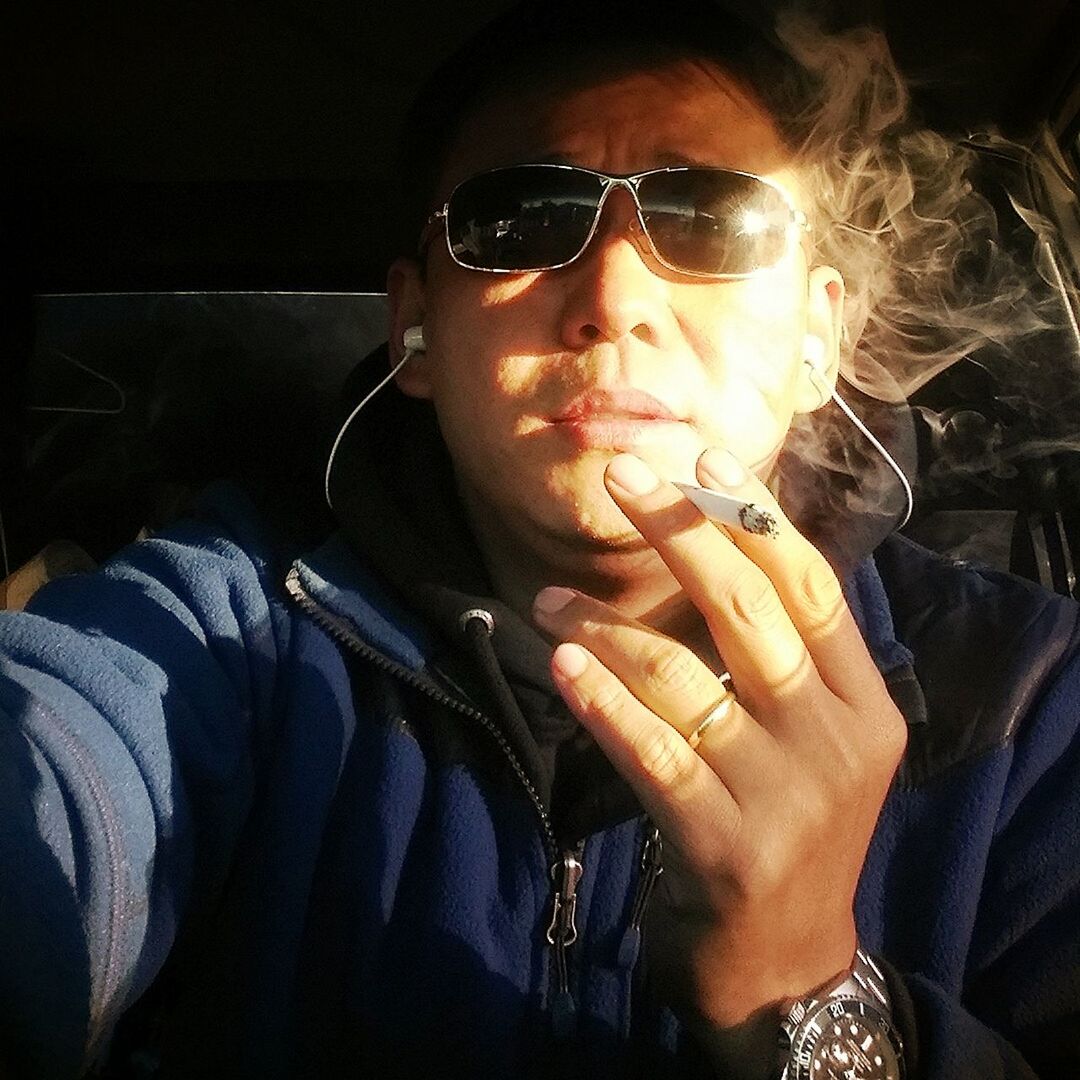 Close-up of man smoking while sitting in car