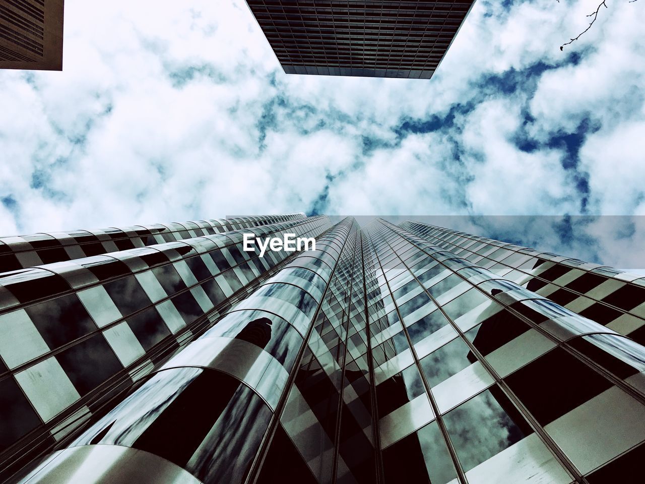 Directly below shot of modern building against cloudy sky