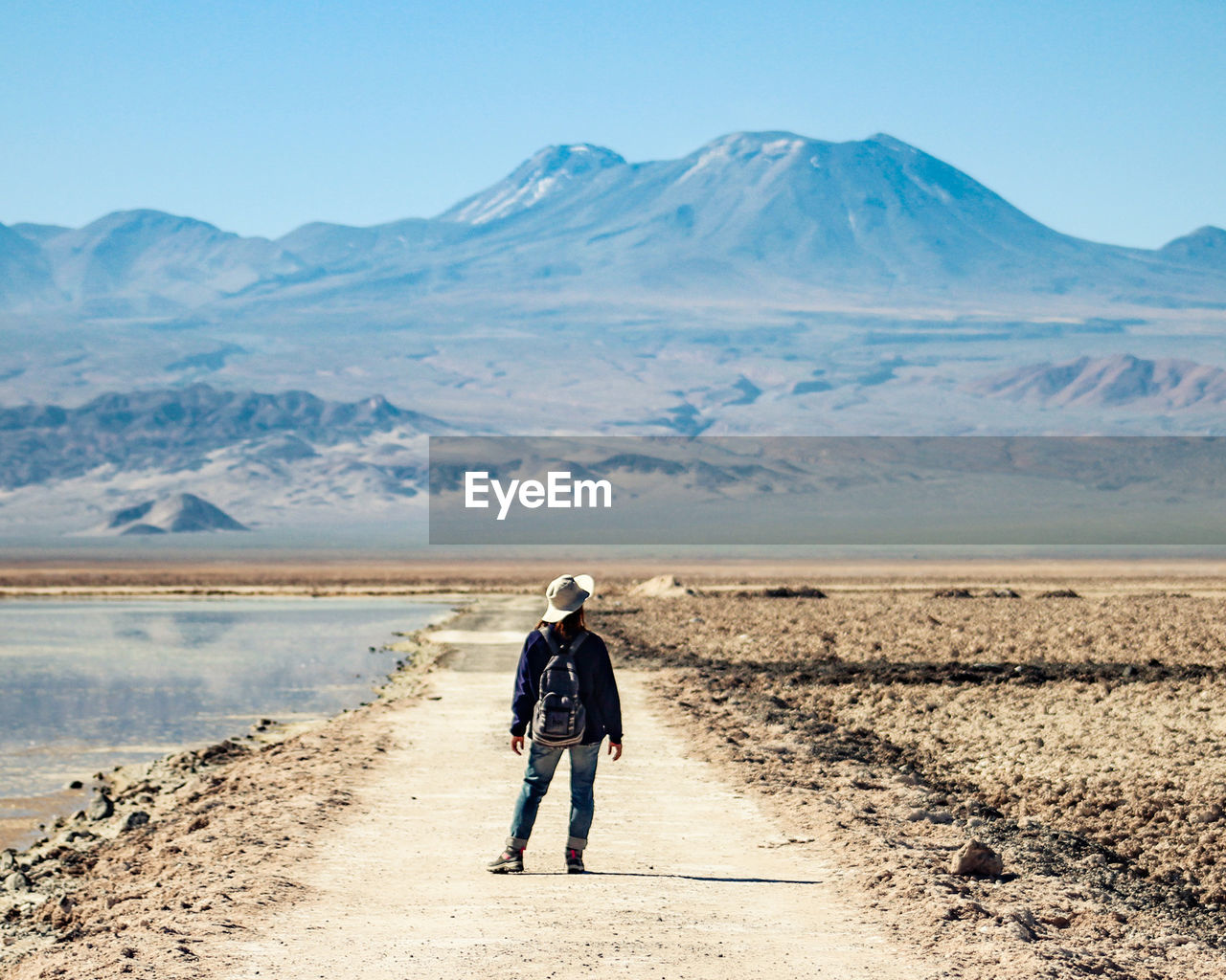 Full length rear view of woman on arid landscape