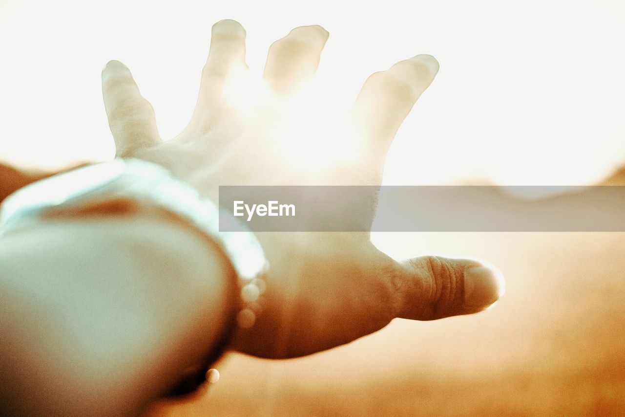 Close-up of hand against sky