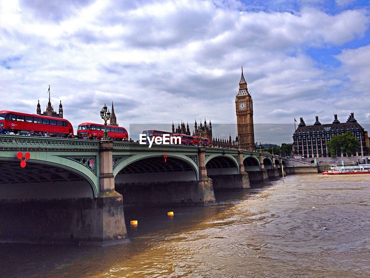 Bridge over river against cloudy sky