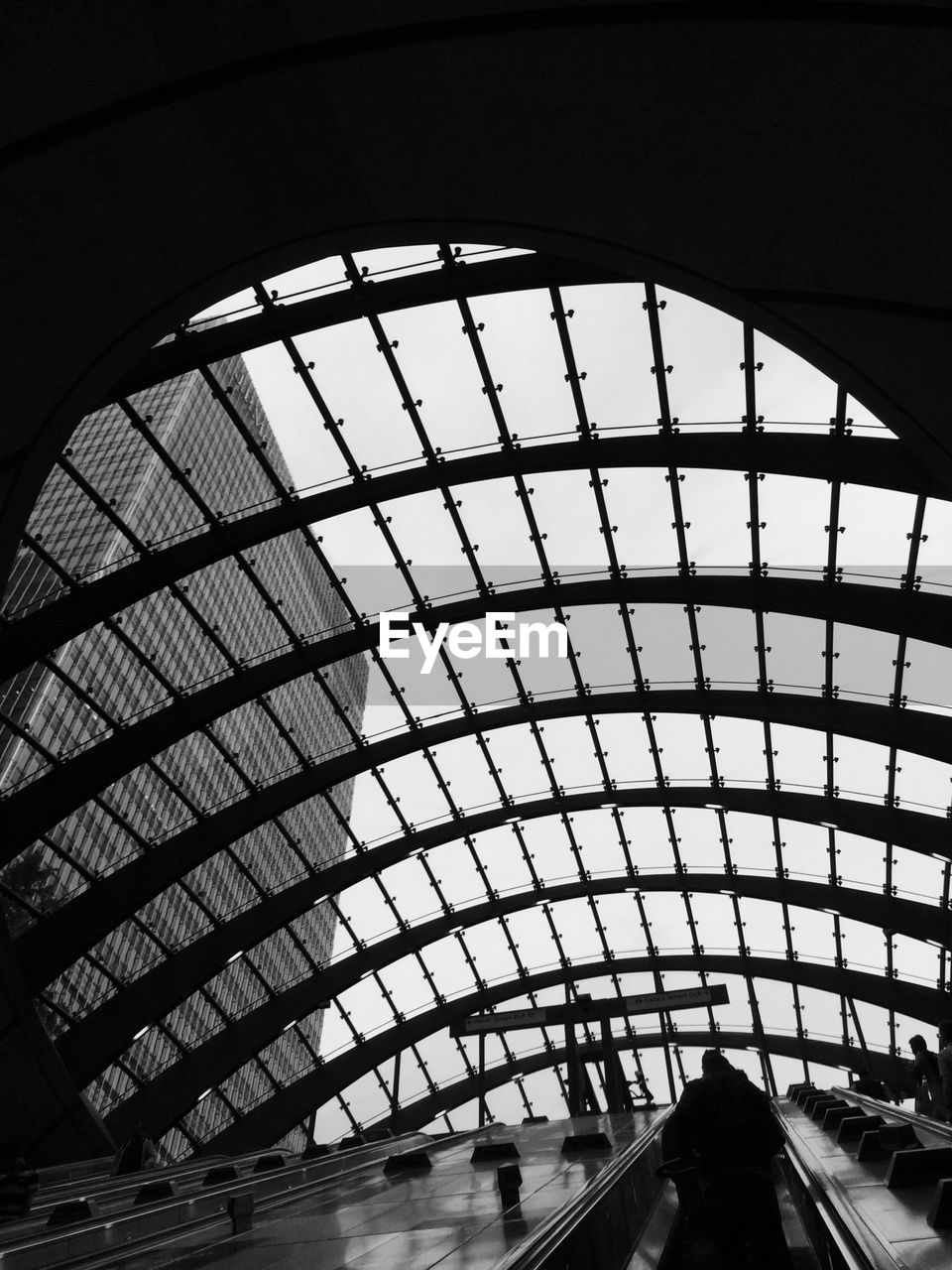 Low angle view of escalator below glass roof