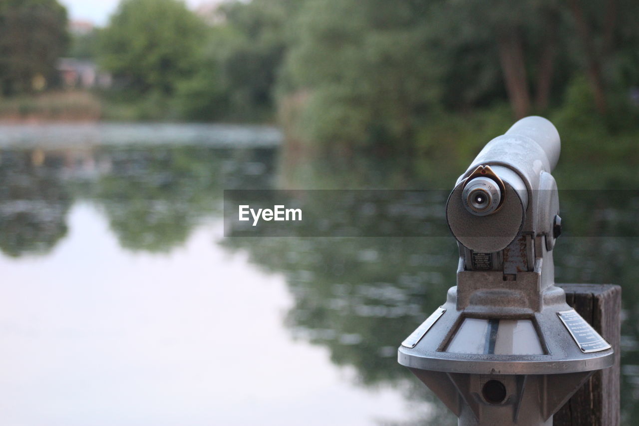 CLOSE-UP OF COIN-OPERATED BINOCULARS AGAINST BLURRED BACKGROUND