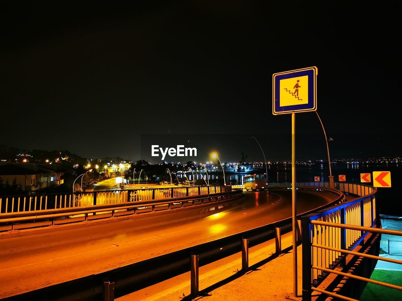 ILLUMINATED LIGHT TRAILS ON ROAD AGAINST SKY AT NIGHT