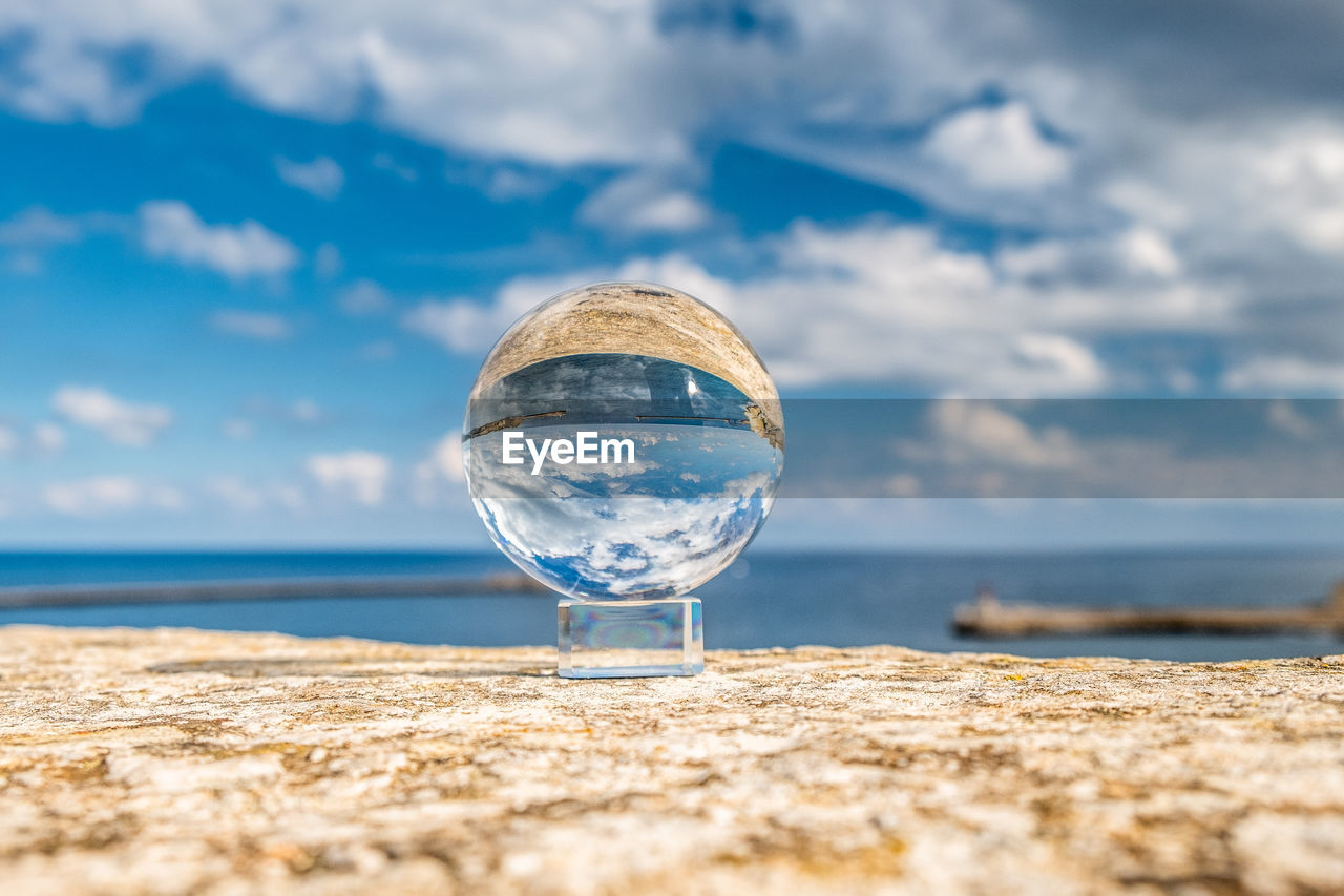 Crystal sphere against sky and sea