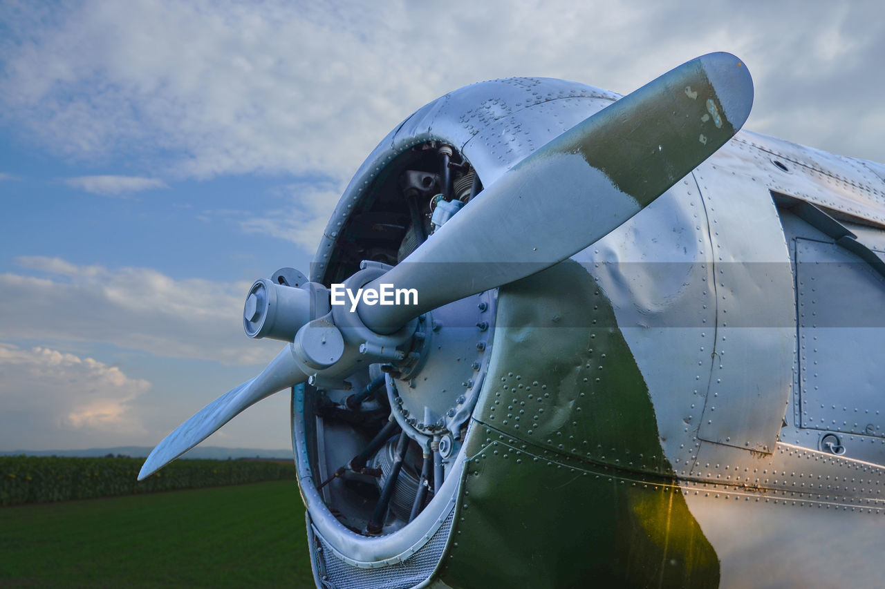 Close-up of airplane on land against sky