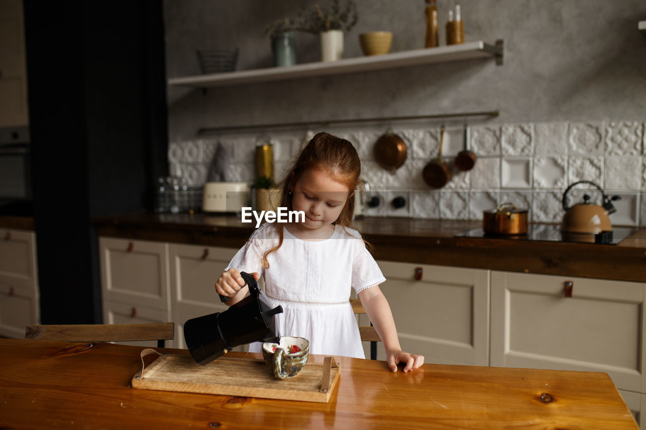 Cute girl preparing food in kitchen