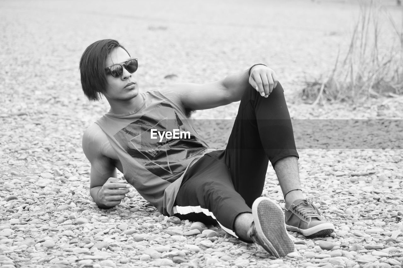 Full length of young man relaxing at beach