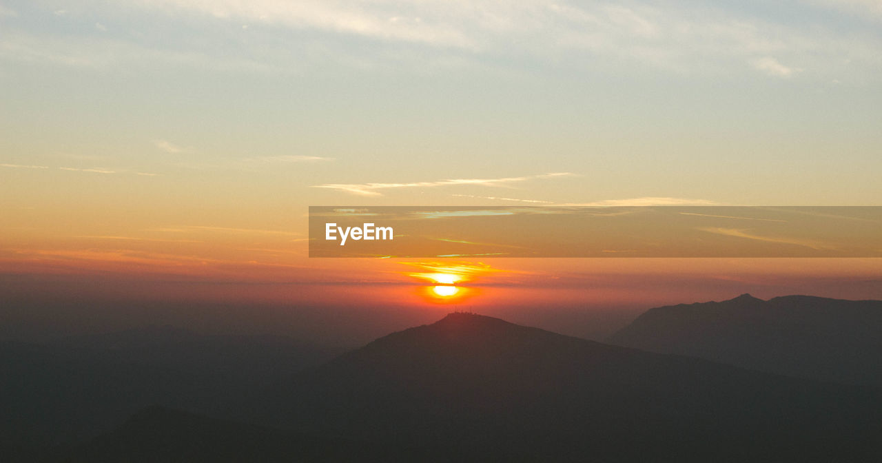 SCENIC VIEW OF SILHOUETTE MOUNTAIN AGAINST SKY AT SUNSET