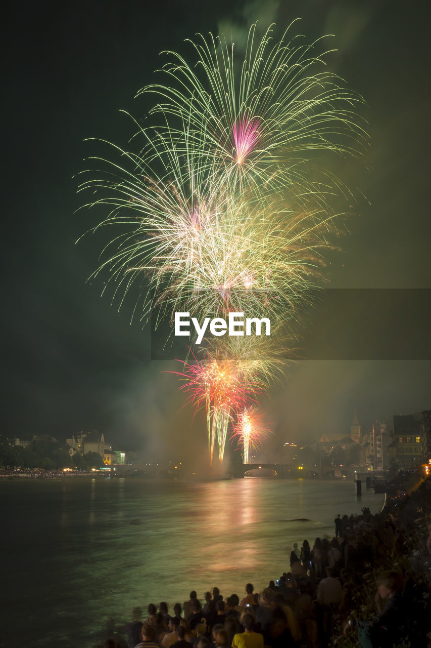 FIREWORK DISPLAY OVER RIVER AGAINST SKY