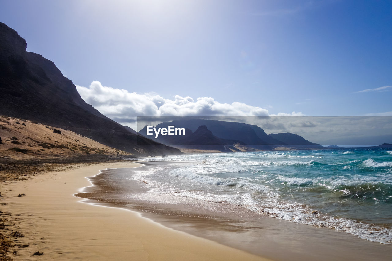 SCENIC VIEW OF BEACH AND MOUNTAINS AGAINST SKY