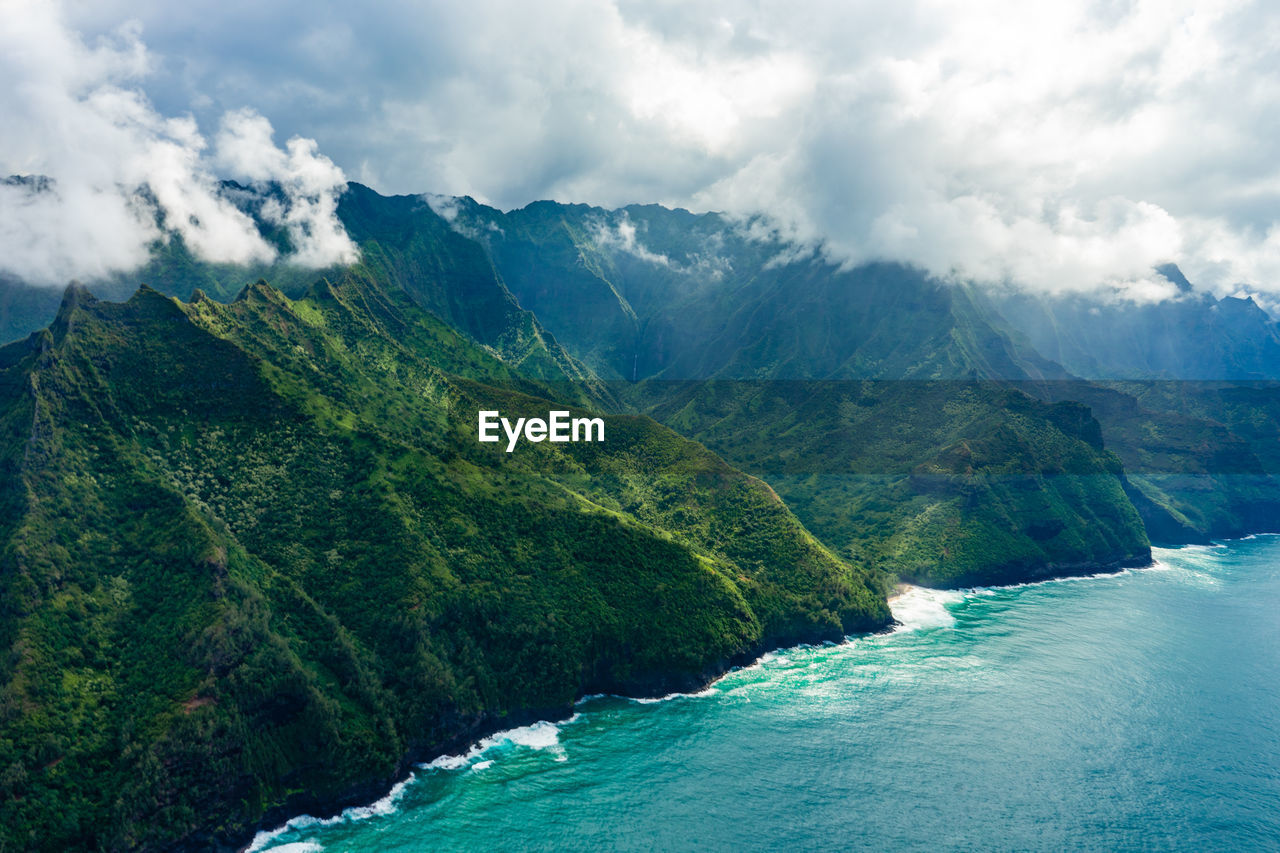 Scenic view of sea and mountains against sky