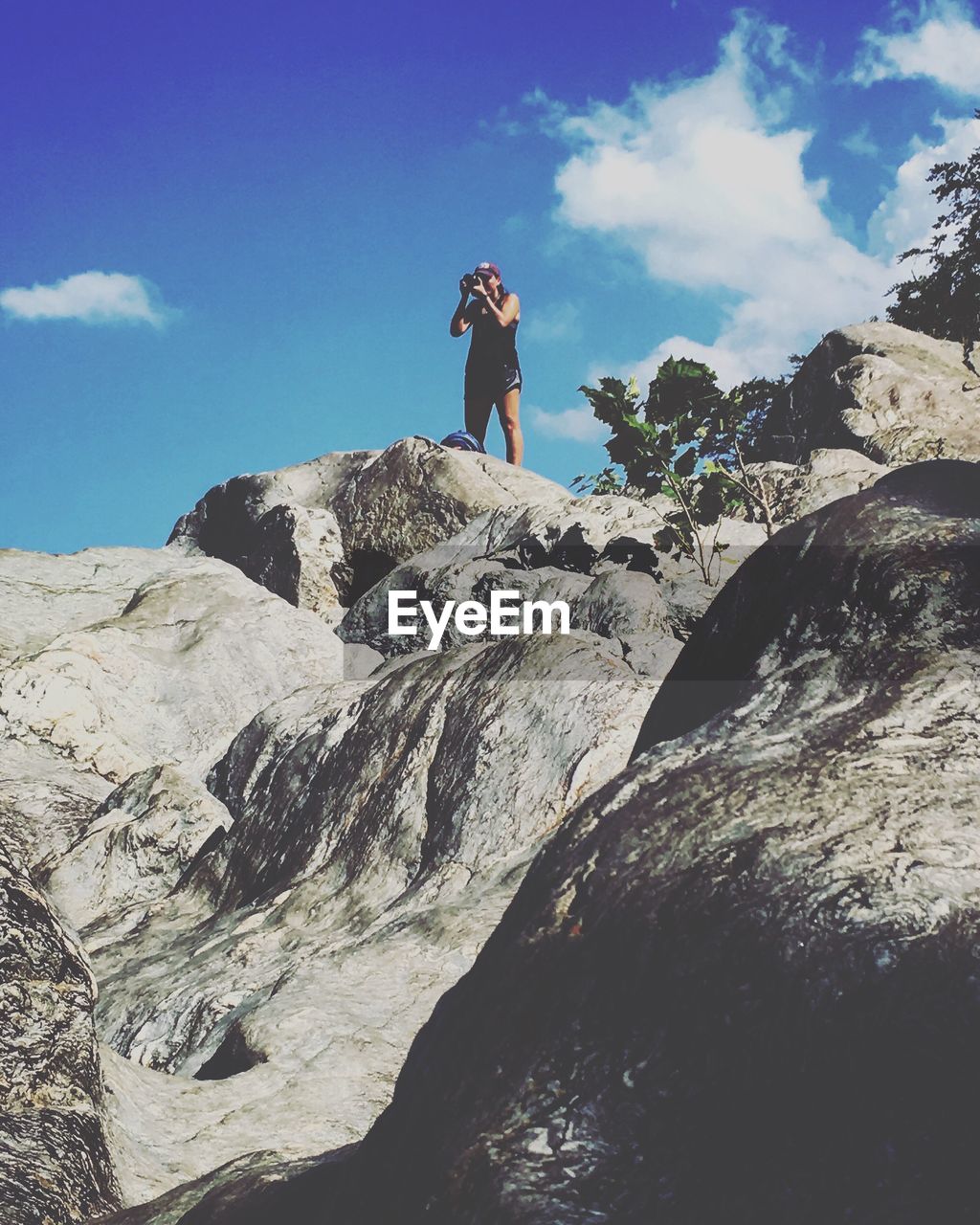 LOW ANGLE VIEW OF MAN STANDING ON MOUNTAIN