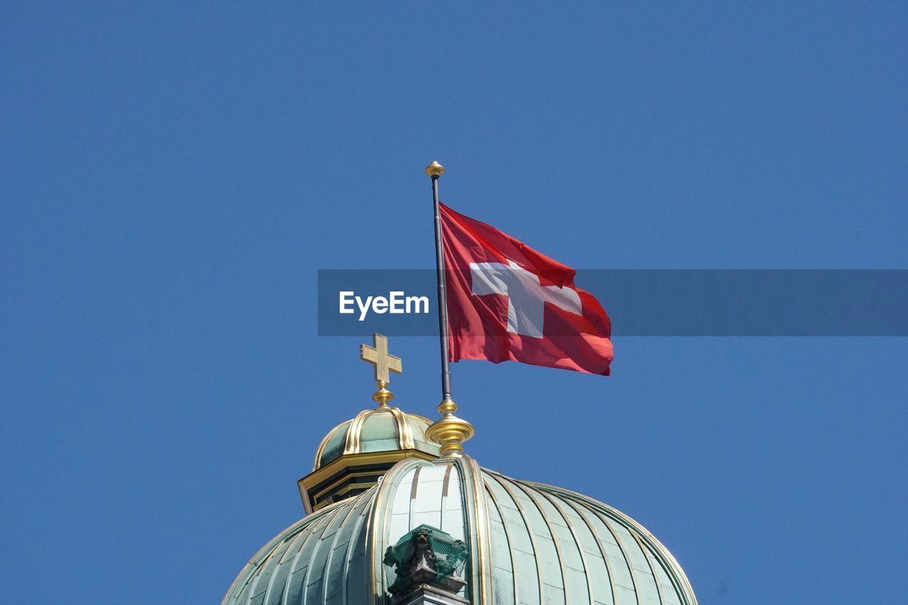 LOW ANGLE VIEW OF FLAGS AGAINST BLUE SKY