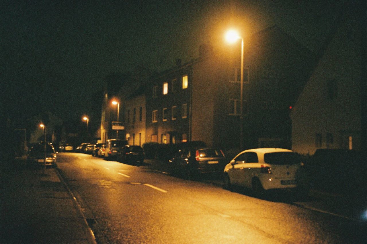 CARS ON ILLUMINATED ROAD AT NIGHT
