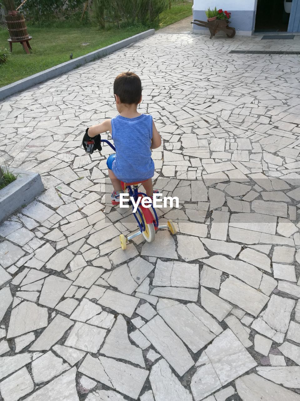 High angle view of boy riding bicycle on footpath