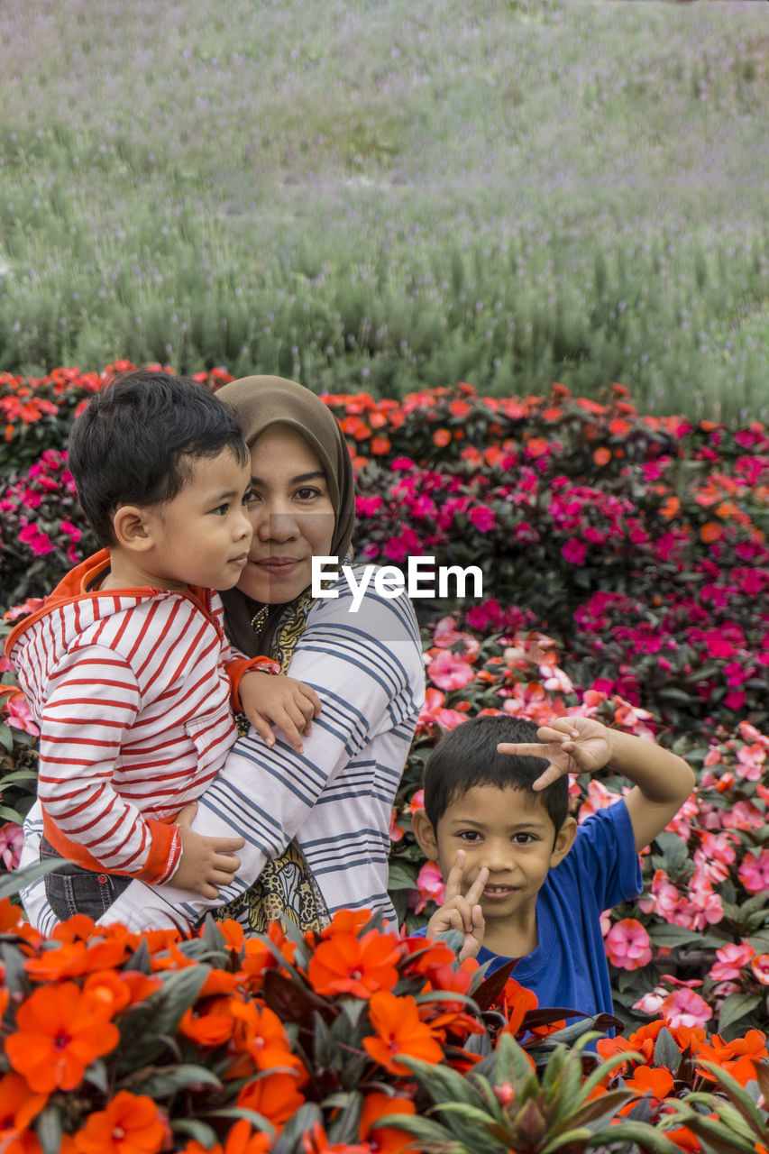 Portrait of mother and son with boy amidst flowering plants