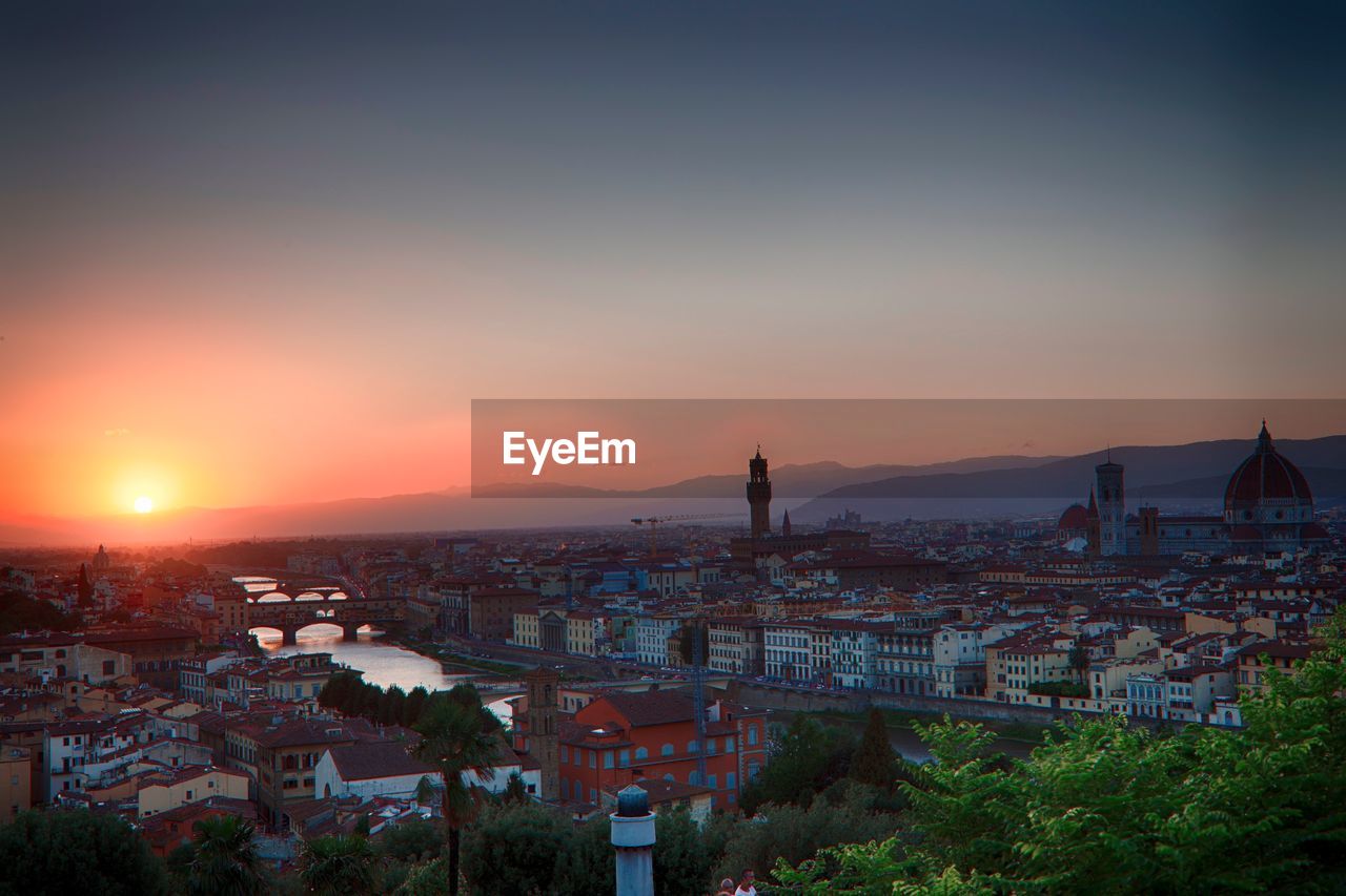 Buildings in city against sky during sunset