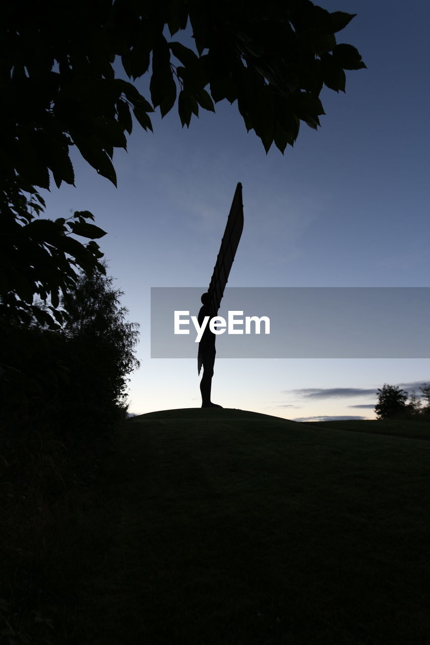 Low angle view of silhouette man standing against sky during sunset